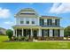 Charming two-story home features a covered front porch, manicured lawn, and craftsman details at 7322 Vesper Dr, Huntersville, NC 28078