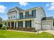 Charming two-story home featuring a well-manicured lawn, blue siding, and an attached two-car garage at 7322 Vesper Dr, Huntersville, NC 28078