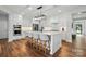 Bright kitchen with an island, modern white cabinetry, stainless steel appliances and hardwood floors at 7322 Vesper Dr, Huntersville, NC 28078