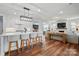 Open-concept space shows the kitchen island with seating that overlooks the living room with a fireplace and TV at 7322 Vesper Dr, Huntersville, NC 28078