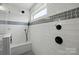 Sleek glass shower featuring modern fixtures and a contrasting gray tiled accent wall at 7322 Vesper Dr, Huntersville, NC 28078