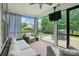 Inviting sunroom with comfortable seating, ceiling fan, and large windows providing serene backyard views at 7322 Vesper Dr, Huntersville, NC 28078