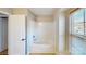 White tub and shower combo in a bright bathroom with window at 8139 Deodora Cedar Ln, Charlotte, NC 28215