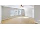 Bright bedroom with a tray ceiling, neutral walls, and carpeted floors and 3 windows at 8139 Deodora Cedar Ln, Charlotte, NC 28215