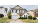 Charming two-story home featuring light yellow siding, a garage, and well-maintained front yard landscaping at 8139 Deodora Cedar Ln, Charlotte, NC 28215