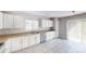 Kitchen featuring white cabinets, stainless steel dishwasher, and tile flooring at 8139 Deodora Cedar Ln, Charlotte, NC 28215