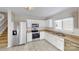 Well-lit kitchen with stainless steel appliances, white cabinets and a double sink at 8139 Deodora Cedar Ln, Charlotte, NC 28215