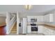 Close up of kitchen featuring stairs, stainless steel appliances, and tile floors at 8139 Deodora Cedar Ln, Charlotte, NC 28215