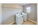 Well-lit laundry room with washer, dryer, wire shelving, and tile flooring at 8139 Deodora Cedar Ln, Charlotte, NC 28215