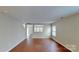 Open concept living room featuring hardwood floors and a view to the staircase and another living area at 8139 Deodora Cedar Ln, Charlotte, NC 28215
