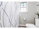 Bright bathroom featuring a decorative shower curtain and natural light from the window at 9011 Kensington Forest Dr, Harrisburg, NC 28075