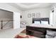 Spacious bedroom with tray ceiling, plush seating, and neutral carpeting throughout at 9011 Kensington Forest Dr, Harrisburg, NC 28075