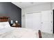 Bedroom with a dark accent wall, cozy bedding, and a closet with bi-fold doors at 9011 Kensington Forest Dr, Harrisburg, NC 28075
