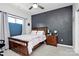 Bedroom features a dark accent wall, natural light from the window, and sleek ceiling fan at 9011 Kensington Forest Dr, Harrisburg, NC 28075