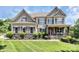 Beautiful two-story home boasts impeccable landscaping and a welcoming front porch at 9011 Kensington Forest Dr, Harrisburg, NC 28075