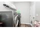 Laundry room with modern appliances, tile flooring, wire shelving, and access door at 9011 Kensington Forest Dr, Harrisburg, NC 28075