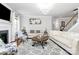 Bright living room featuring a fireplace, large windows, and stylish neutral decor at 9011 Kensington Forest Dr, Harrisburg, NC 28075