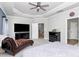 Spacious bedroom with sitting chair, ceiling fan and access to the upper floor stairs at 9011 Kensington Forest Dr, Harrisburg, NC 28075