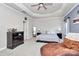 A spacious bedroom with a tray ceiling, ceiling fan, bedside tables and sitting chair at 9011 Kensington Forest Dr, Harrisburg, NC 28075