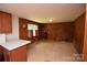 Cozy living room with paneled walls and tile flooring, featuring a front-facing window and a wooden door at 908 Ravendale Dr, Charlotte, NC 28216
