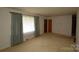 Spacious living room with carpet, a window, and a door providing a blank canvas for personalization at 908 Ravendale Dr, Charlotte, NC 28216