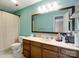 Bathroom featuring turquoise walls, a wooden-framed mirror, and ample counter space at 9121 Kings Canyon Dr, Charlotte, NC 28210