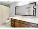 Bathroom featuring a white countertop, wooden cabinets, large framed mirror, and tiled floors at 9121 Kings Canyon Dr, Charlotte, NC 28210