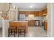 Well-lit kitchen featuring wooden cabinetry, stainless steel appliances, and stylish breakfast bar with stool seating at 9121 Kings Canyon Dr, Charlotte, NC 28210