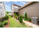 Well-maintained backyard featuring a sidewalk, manicured shrubs, and string lights at 915 Claires Creek Ln, Davidson, NC 28036
