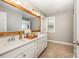 Bathroom featuring double vanity with ample counter space, wooden framed mirror, and warm neutral colors at 915 Claires Creek Ln, Davidson, NC 28036