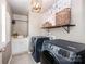 Well-lit laundry room with modern washer and dryer units, cabinets, and tile floors at 915 Claires Creek Ln, Davidson, NC 28036