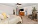 Relaxing main bedroom featuring a queen size bed, ceiling fan, bench, and tree at 915 Claires Creek Ln, Davidson, NC 28036