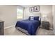 Comfortable bedroom with blue bedding, neutral walls, and window for natural light creates inviting atmosphere at 10108 Florentine Way, Charlotte, NC 28214