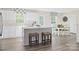 Eat-in kitchen with white cabinetry, quartz countertops, an island with barstools, and hardwood floors at 10108 Florentine Way, Charlotte, NC 28214