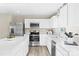 Bright kitchen with stainless steel appliances, white cabinets, quartz countertops, tile backsplash, and plank flooring at 10108 Florentine Way, Charlotte, NC 28214