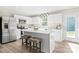Modern kitchen features white cabinetry, stainless steel appliances, quartz countertops, and a kitchen island with barstool seating at 10108 Florentine Way, Charlotte, NC 28214
