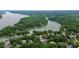 Scenic aerial view of a home nestled among lush trees with lake access, marked with an arrow for emphasis at 10449 Quiet Bay Ct, Charlotte, NC 28278