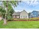 Charming two-story home featuring a stone porch, dormer windows, green shutters, and a beautifully landscaped front yard at 10449 Quiet Bay Ct, Charlotte, NC 28278