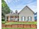 Charming two-story home featuring a stone porch, dormer windows, green shutters, and a beautifully landscaped front yard at 10449 Quiet Bay Ct, Charlotte, NC 28278