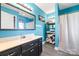 Well-lit bathroom featuring blue walls, a vanity with a sink, a framed mirror, and a shower with a curtain at 105 Saddlewood Ln, Statesville, NC 28625