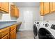 Functional laundry room with cabinets, a folding counter, and a modern washing machine and dryer at 105 Saddlewood Ln, Statesville, NC 28625