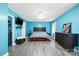 Bright main bedroom featuring blue walls, wood-look floors, and neutral-toned accents, offering a relaxing retreat at 105 Saddlewood Ln, Statesville, NC 28625