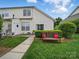 A townhome backyard featuring a bench, trimmed hedges, and a paved walkway at 1061 Woodglen Ln, Matthews, NC 28104