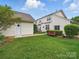 Backyard featuring a detached garage, green grass, and inviting outdoor bench at 1061 Woodglen Ln, Matthews, NC 28104