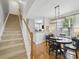 A dining room is open to the stairs and kitchen with a modern light fixture and large window at 1061 Woodglen Ln, Matthews, NC 28104