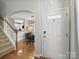 Welcoming foyer featuring hardwood floors, staircase, and an arched entryway to the dining area and kitchen at 1061 Woodglen Ln, Matthews, NC 28104
