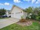 Detached two-car garage with white doors, set amidst a well-kept lawn and landscaping at 1061 Woodglen Ln, Matthews, NC 28104