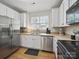 This kitchen is equipped with stainless steel appliances, white cabinets, and a double sink at 1061 Woodglen Ln, Matthews, NC 28104