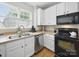 Kitchen features modern black appliances, a stainless steel dishwasher, and light-colored countertops at 1061 Woodglen Ln, Matthews, NC 28104
