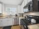 Kitchen features modern black appliances, a stainless steel dishwasher, and light-colored countertops at 1061 Woodglen Ln, Matthews, NC 28104